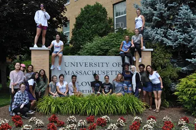 This is the group of twenty one young women who joined the RAMP program in summer of 2018, posing in front of and top of the large Univ. of Massachusetts Lowell sign on university ave. they look happy and eager to get started. 