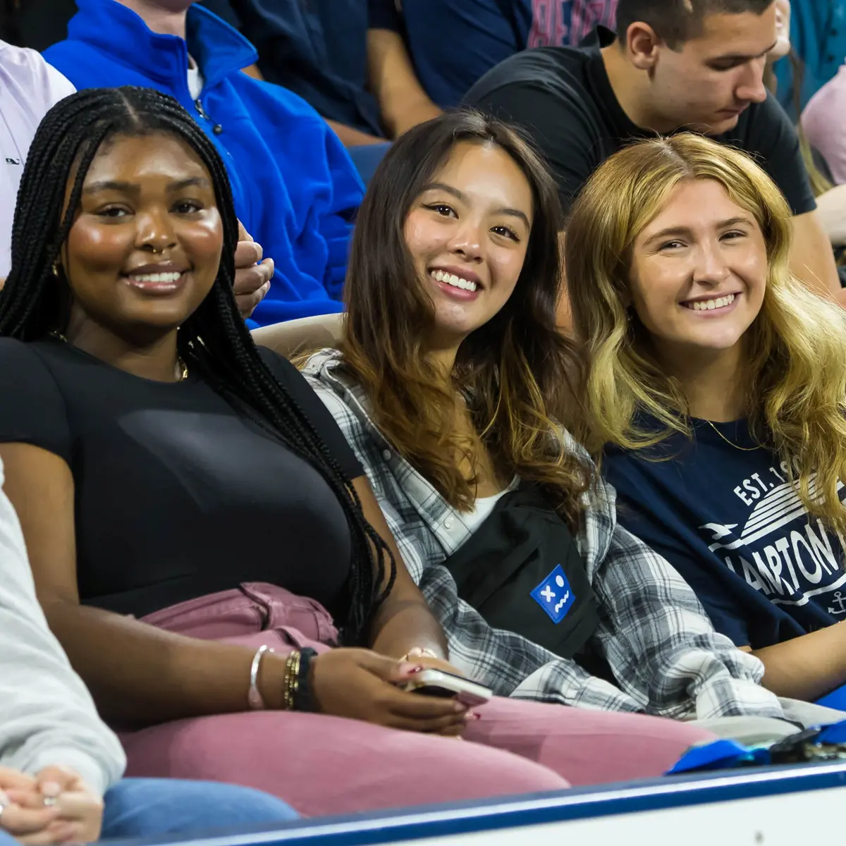 Three students sitting in seats at the Tsongas Center