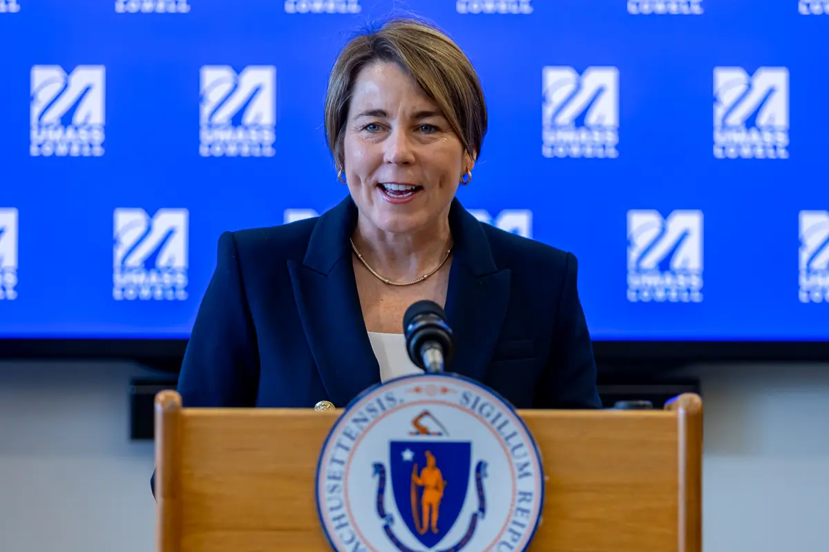Woman with short brown hair stands at a podium 