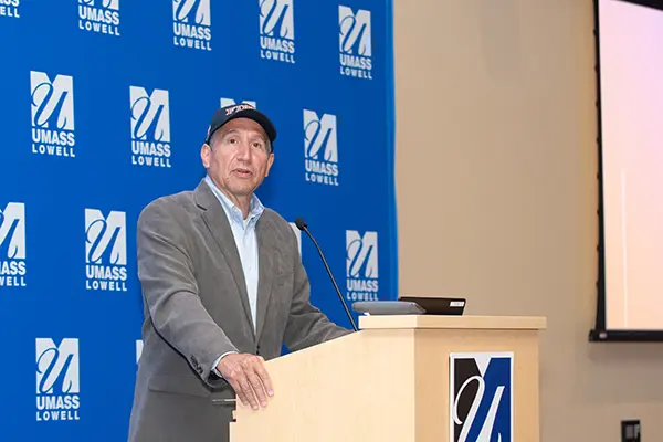 UML Political Science Prof. Jeffrey Gerson, wearing an FDNY cap, introduces Ret. FDNY Battalion Cmdr. Jack Oehm