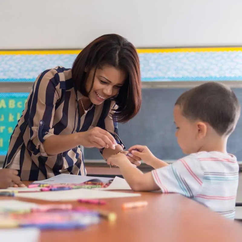 Teacher working with a student in an elementary school classroom