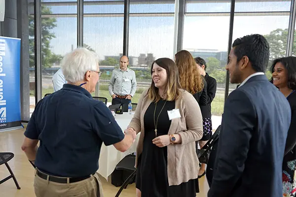 A student shakes hands with keynote speaker Harvey Lodish