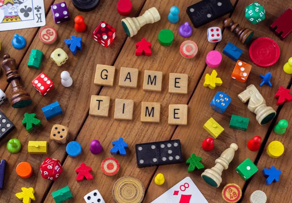 Game time spelled out with wooden tiles surrounding by various games pieces.