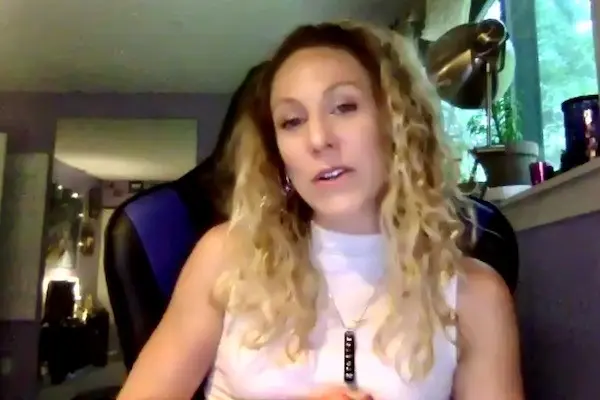 A woman talks from her office on Zoom