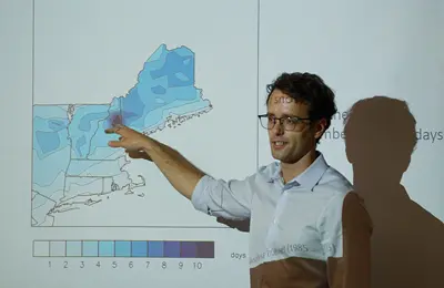 Faculty pointing to a map on the wall