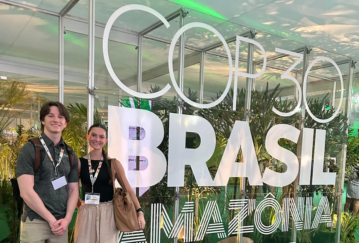 Colin Ormond and Cate Kleeman stand next to a COP 30 Brasil Amazonia sign.