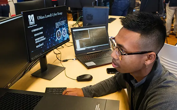 Photo shows student wokring at a desktop computer in UMass Lowell's Cyber Range
