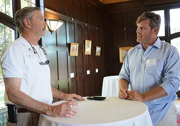 Christopher Clinton (right), a lecturer at UMass Dartmouth's School of Education, chats with Martin Trice at Allen House. Both are graduate students in UMass Lowell's online Ed.D. degree program