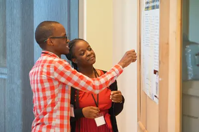 Seven people pose for a photo standing in front of an academic poster. 