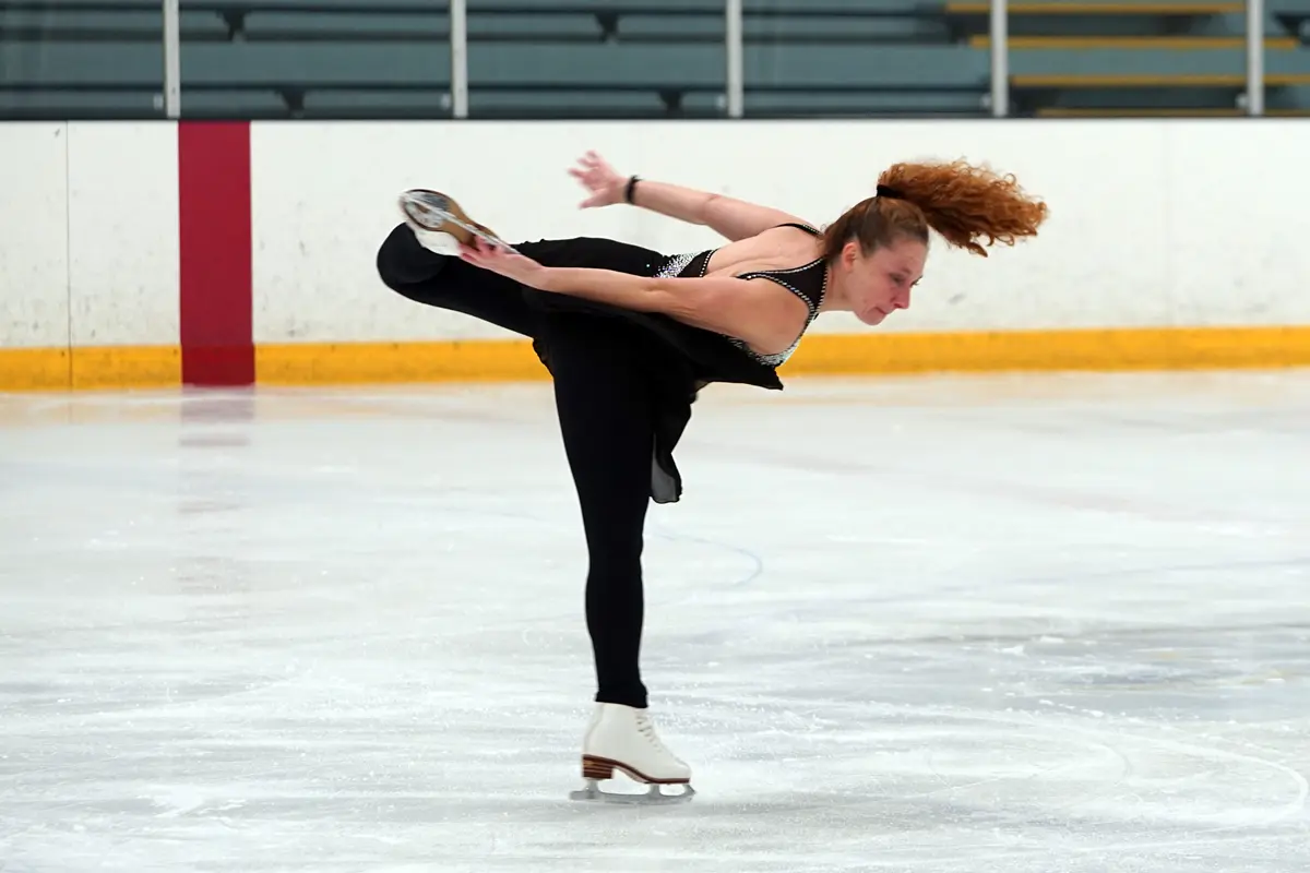 A woman spins on one leg while figure skating.
