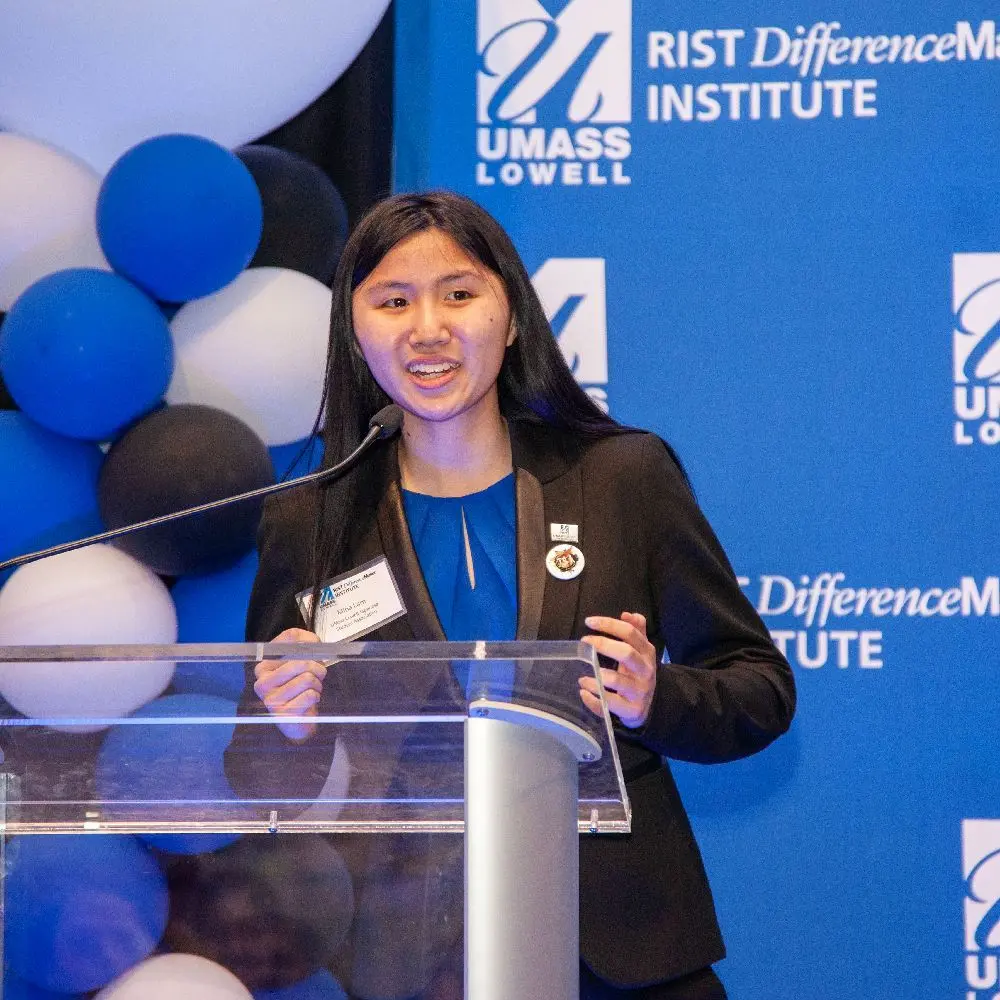 Student speaks at podium in front of Rist Diffencemaker banner