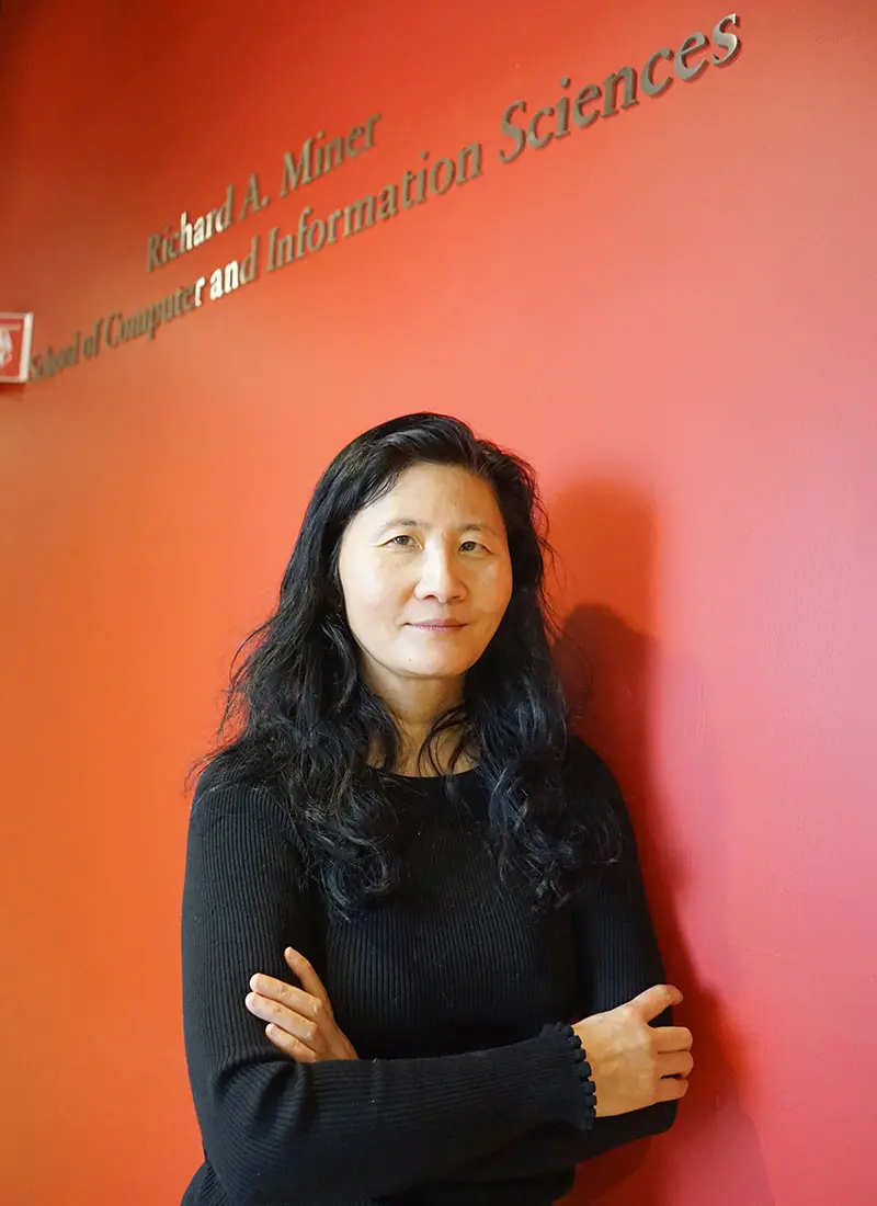 CS Prof. Hong Yu in front of Miner School sign