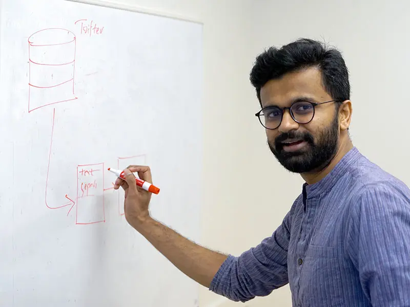 Ph.D. student Vijeta Deshpande writes on a white board