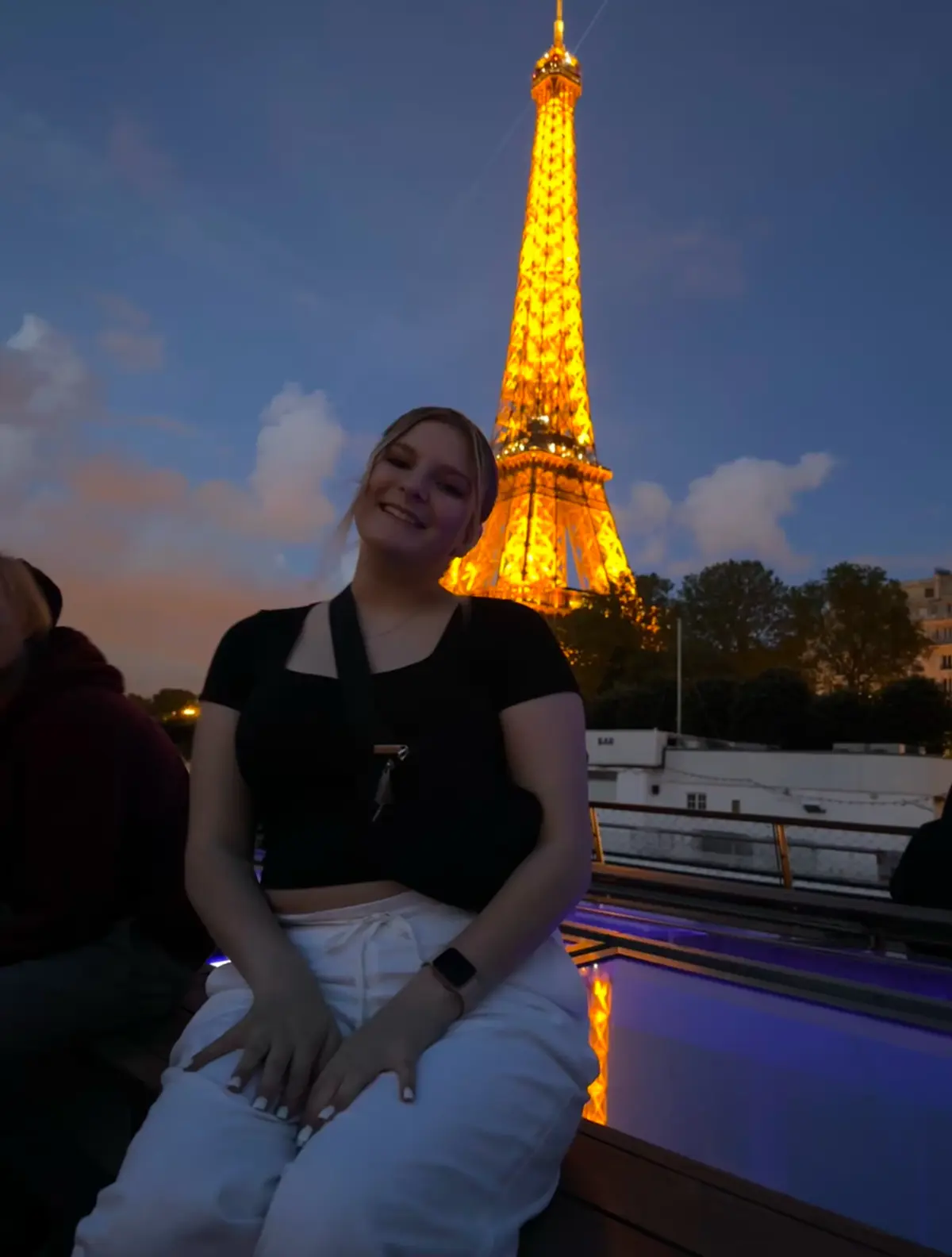 Honors College history student poses in front of the Eiffel Tower at night