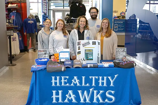 students and staff pose for a photo at the vape pen exchange table