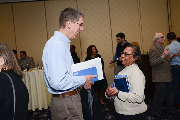 Faculty members talk during a break at the symposium
