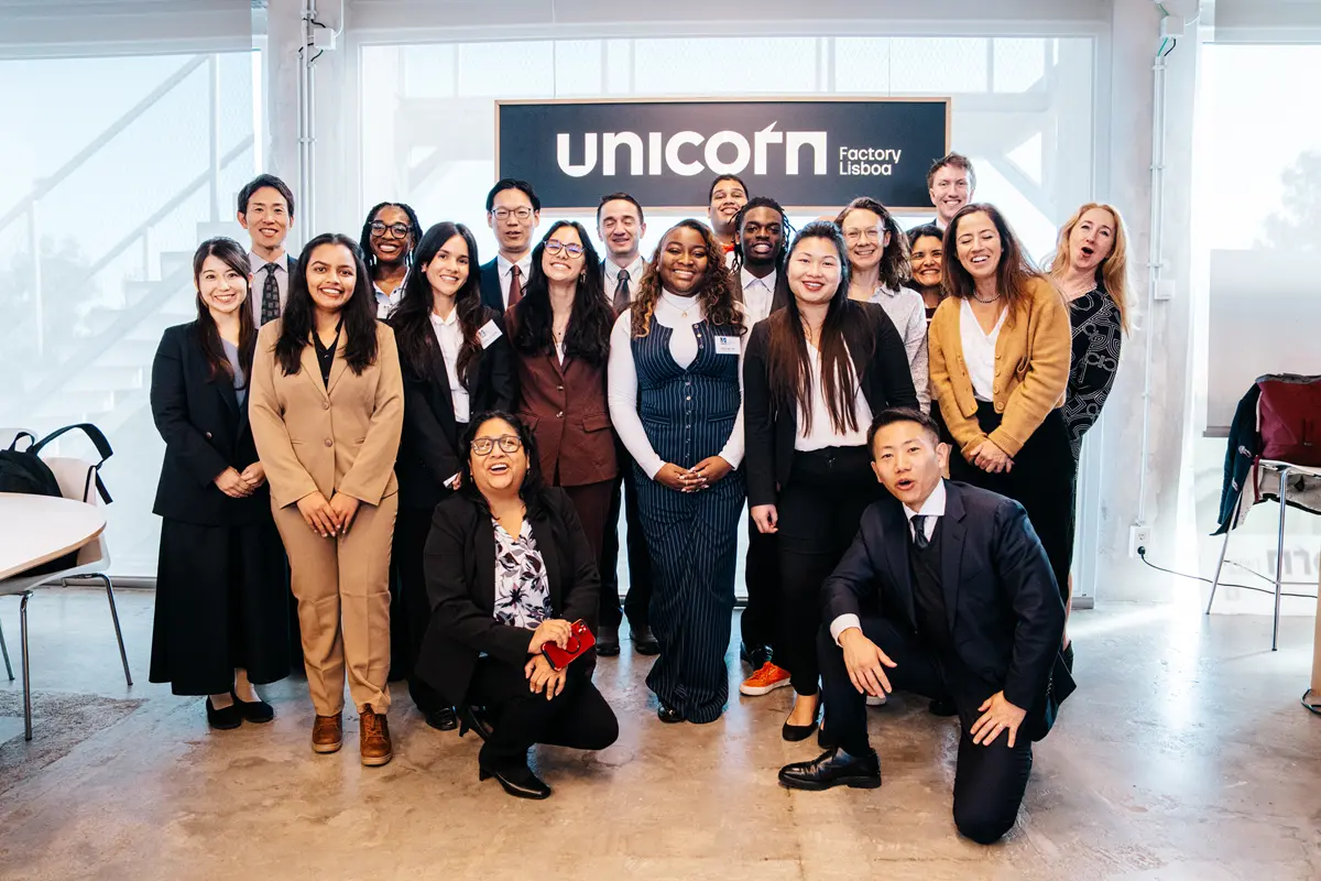 Twenty men and women pose for a group photo in a conference room.