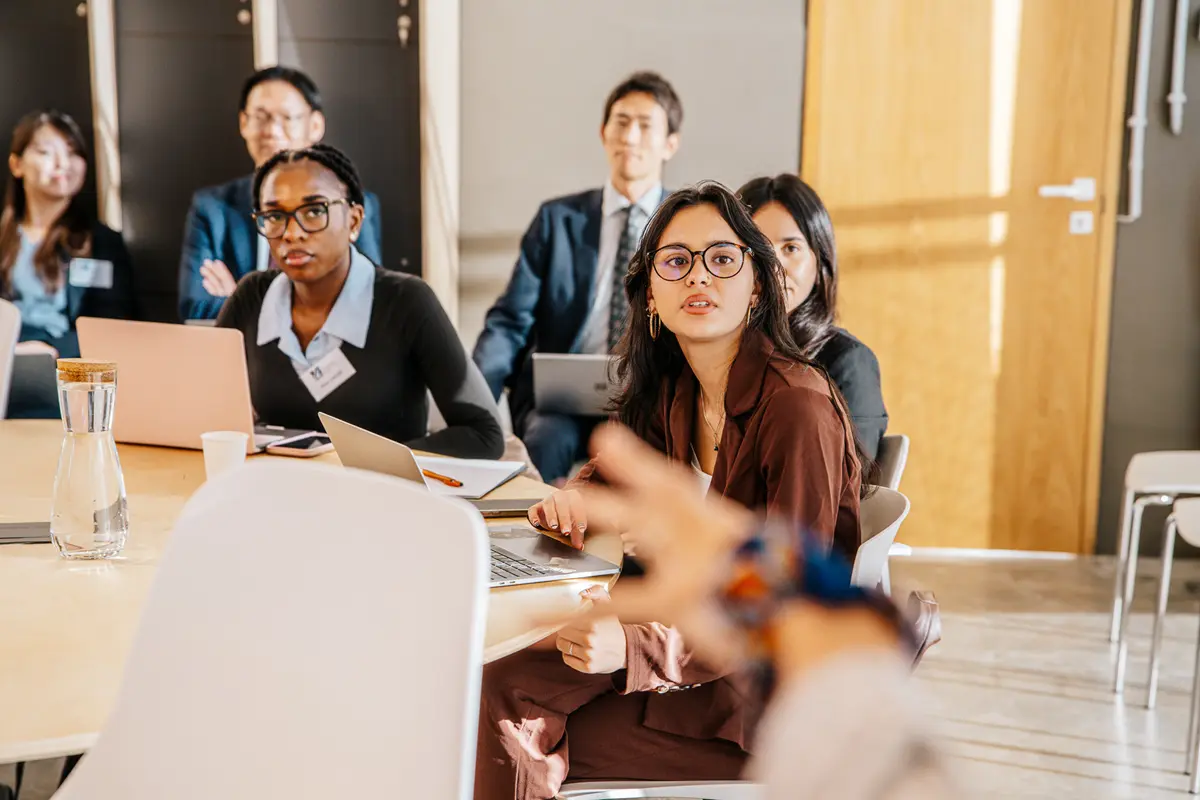 Twenty men and women pose for a group photo in a conference room.