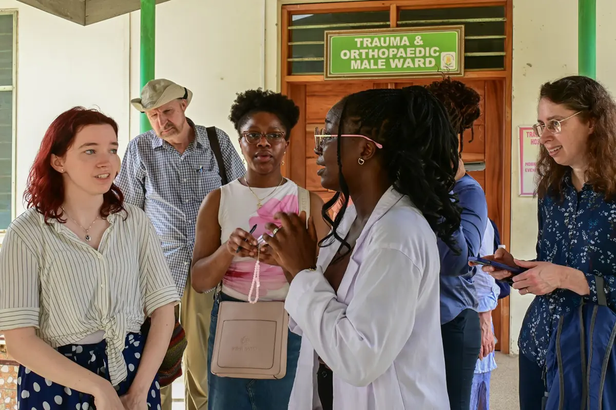 A doctor talks to a group of people at a hospital.