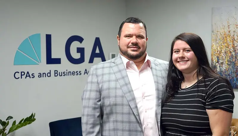Gianna Geraci stands with her Dad in front of LGA logo