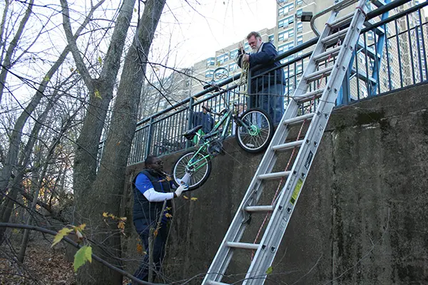 Grad student Mark-Henry Kamga helps raise a bike he found