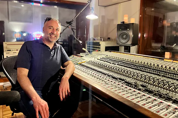 Greg Capolino sits next to a massive sound board in Cherokee Studios.