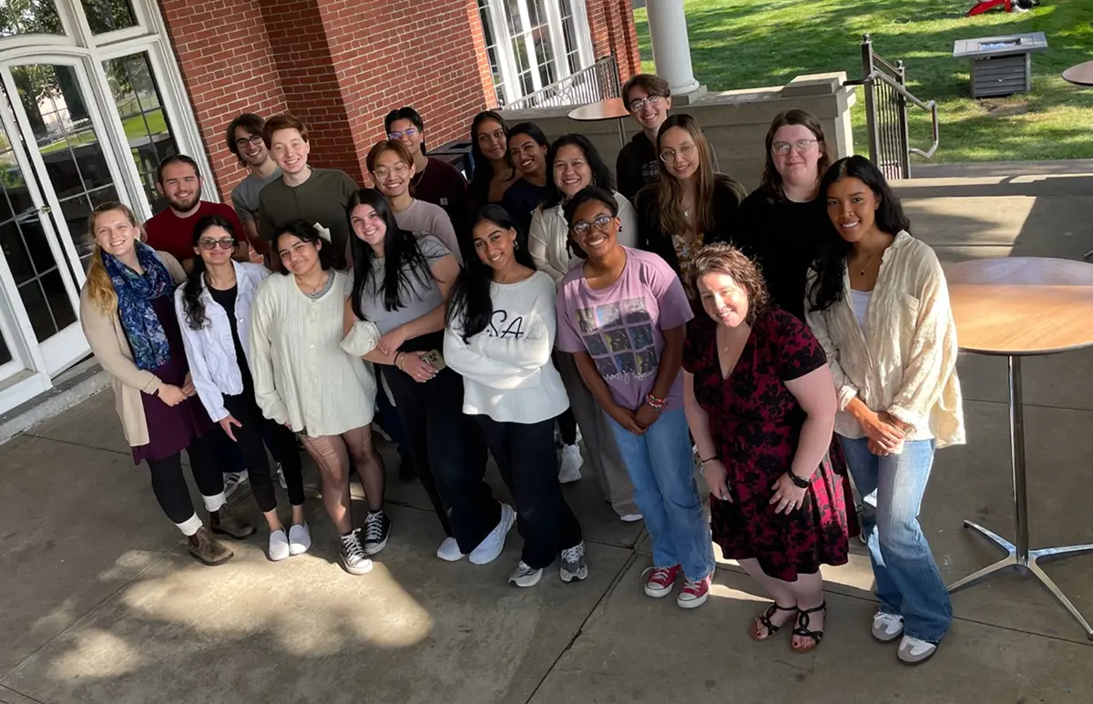 Students and faculty group photo standing on Allen House porch.