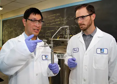 Asst. Profs. Hsi-Wu Wong and Hunter Mack examine the reactor used in creating biofuels in the lab.