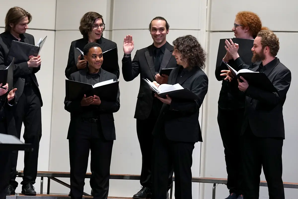 Joe Paquin surrounded by a group of singers.