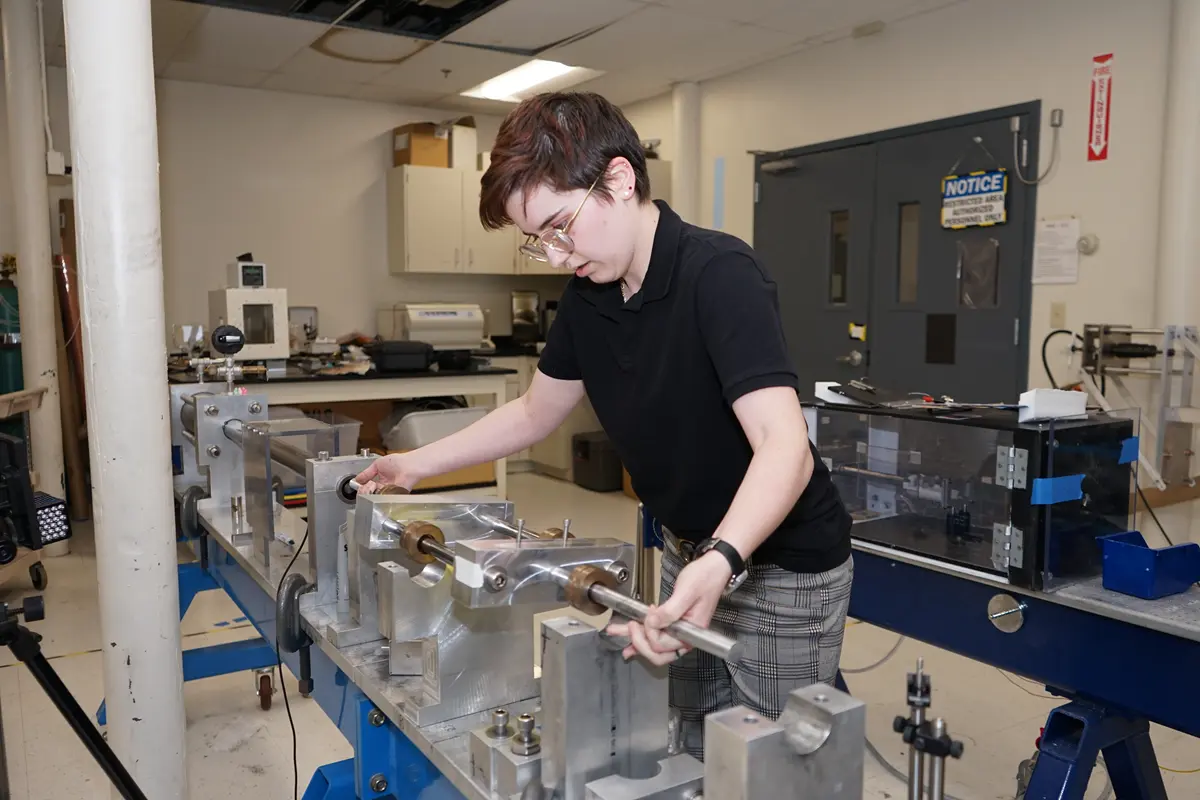 Kay Wojtowicz uses a split-Hopkinson pressure bar in UMass Lowell's mechanical engineering research lab.