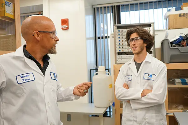 Biologist Nicolai Konow talks with honors student Jacob Solomon in the lab.