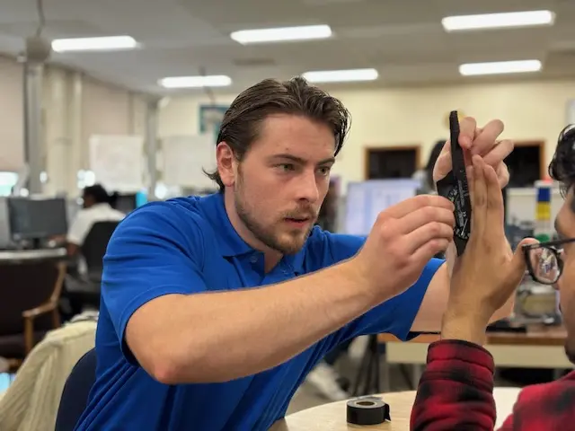 Physical therapy student Kyle Callahan measures range of motion on someone's hand