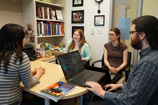 Jordi Love talks to Asst. Prof. Miko Wilford about the PleaJustice.org project while Thomas Nelson and Kathrine Lucas listen