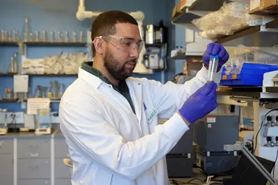 Macro Vargas examines a beaker inside a lab.