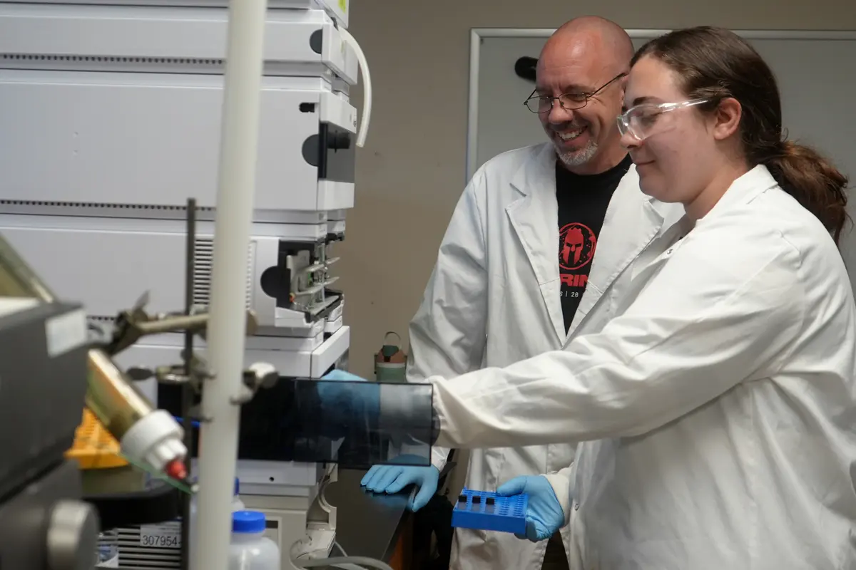 Mary Harutyunyan and Matthew Gage use a peptide analyzer.