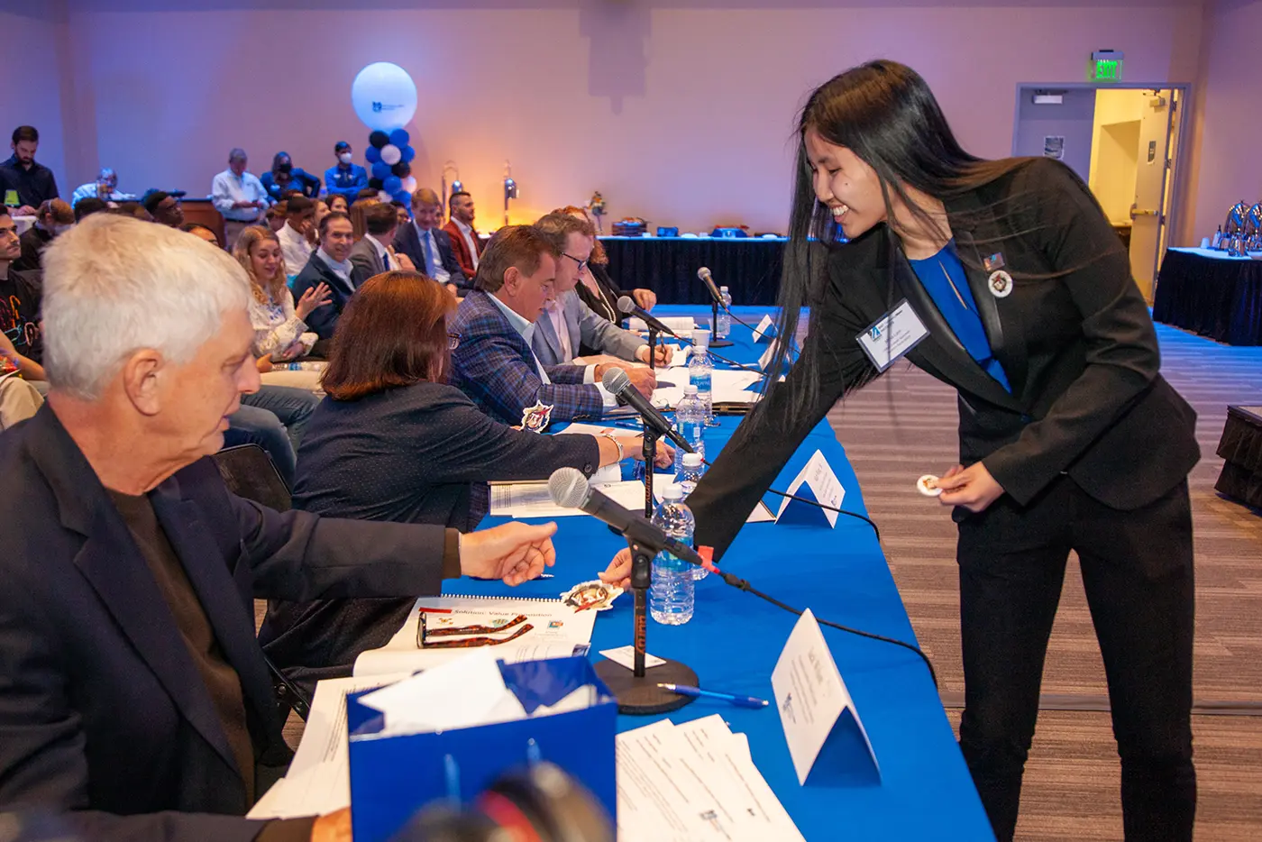 Mina Lam, a junior business administration major, handing out buttons and stickers for the UMass Lowell Japanese Student Association (UMLJSA).