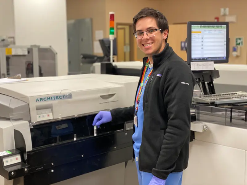 Nicolas Troisi works at a piece of equipment in a medical laboratory.