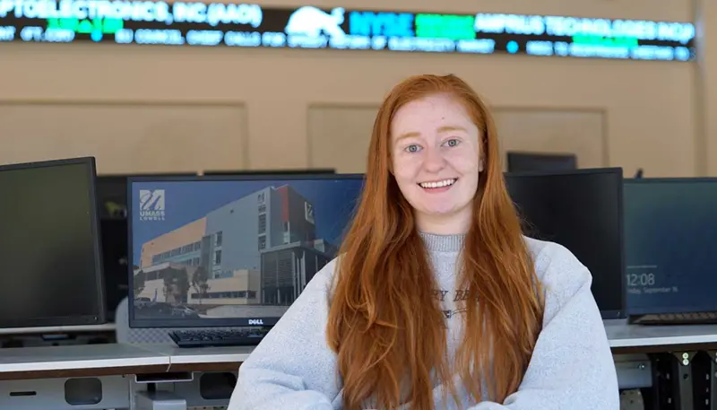 Olivia Hebert seated in front of a set of computers