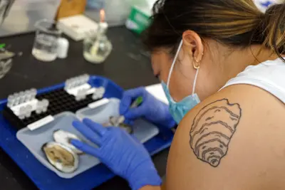 Two men and five women stand and pose for a photo in a science lab.