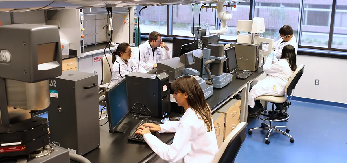 People wearing lab coats in labs working on computers.