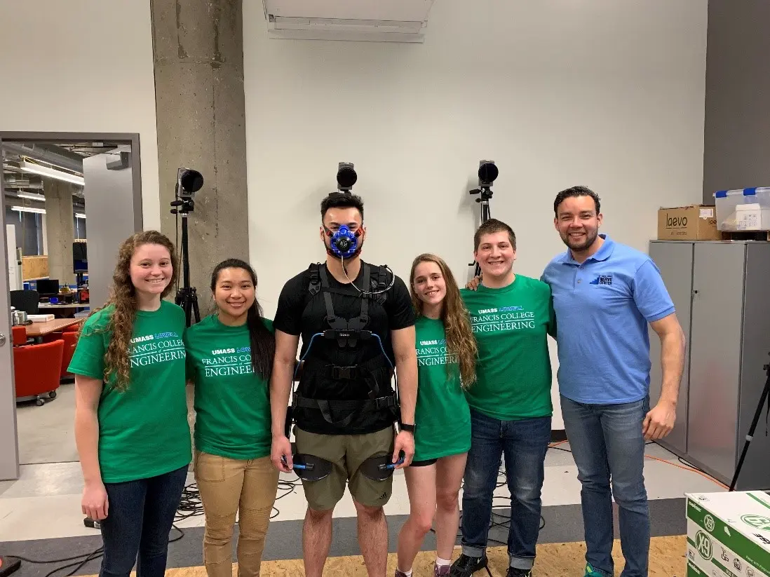 Graduate Student, Jose Pacheco, demonstrating his exoskeleton suit with the help of Anthony Vo and BME students.