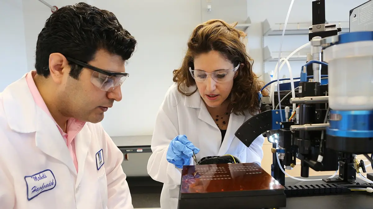 Man and woman looking at output from a machine in a lab