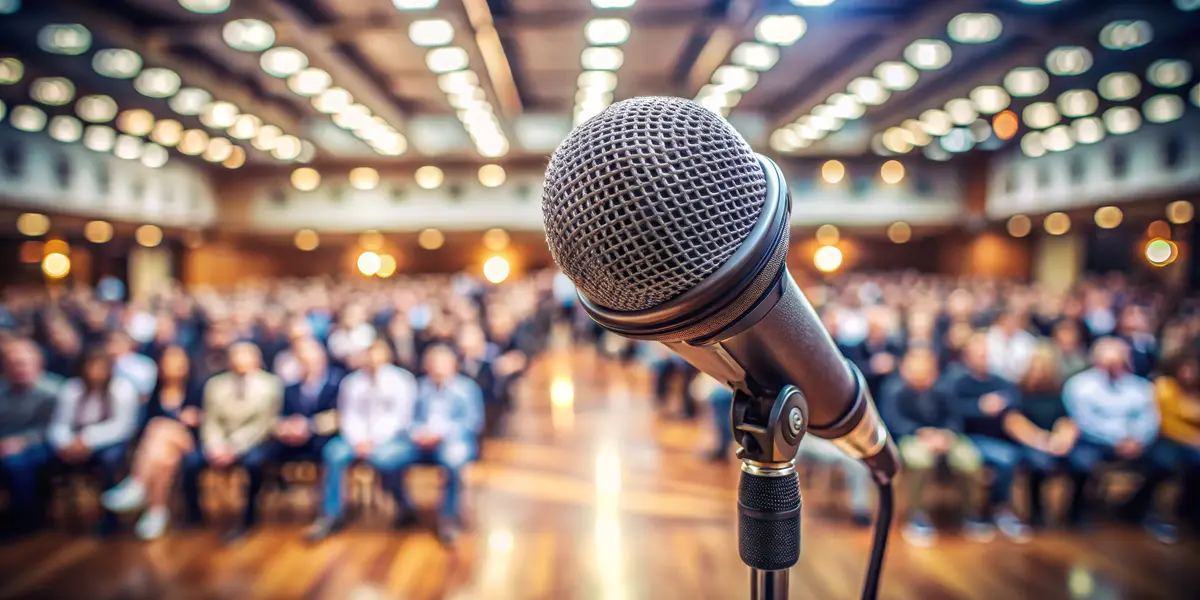 Microphone Close Up in Front of Blurred Audience.