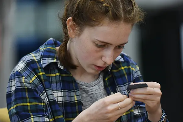 Breanne Eriksen learns how to sew patches at the UMass Lowell Repair Cafe