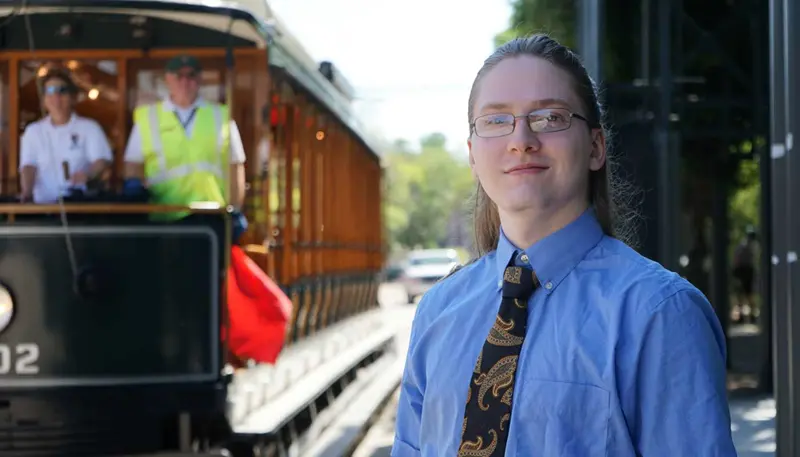 Rory Luddy poses in front of a trolley