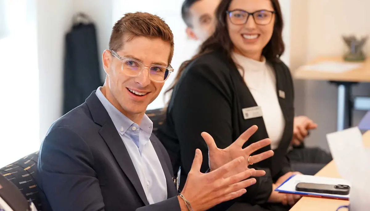 Ryan MacInnis speaks at a table while others listen.