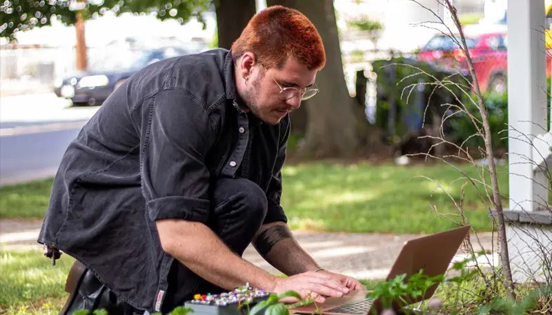 Ryan Katz working on a laptop outdoors