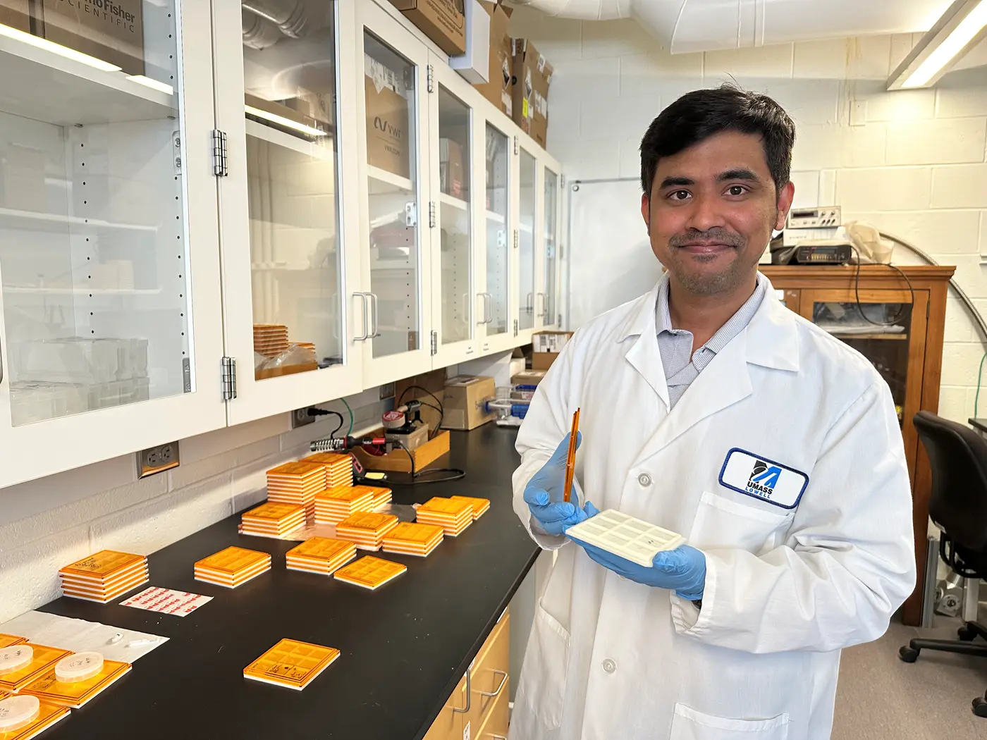 Asst. Engineering Prof. Anhar Bhuiyan holds up a tray of gallium oxide samples