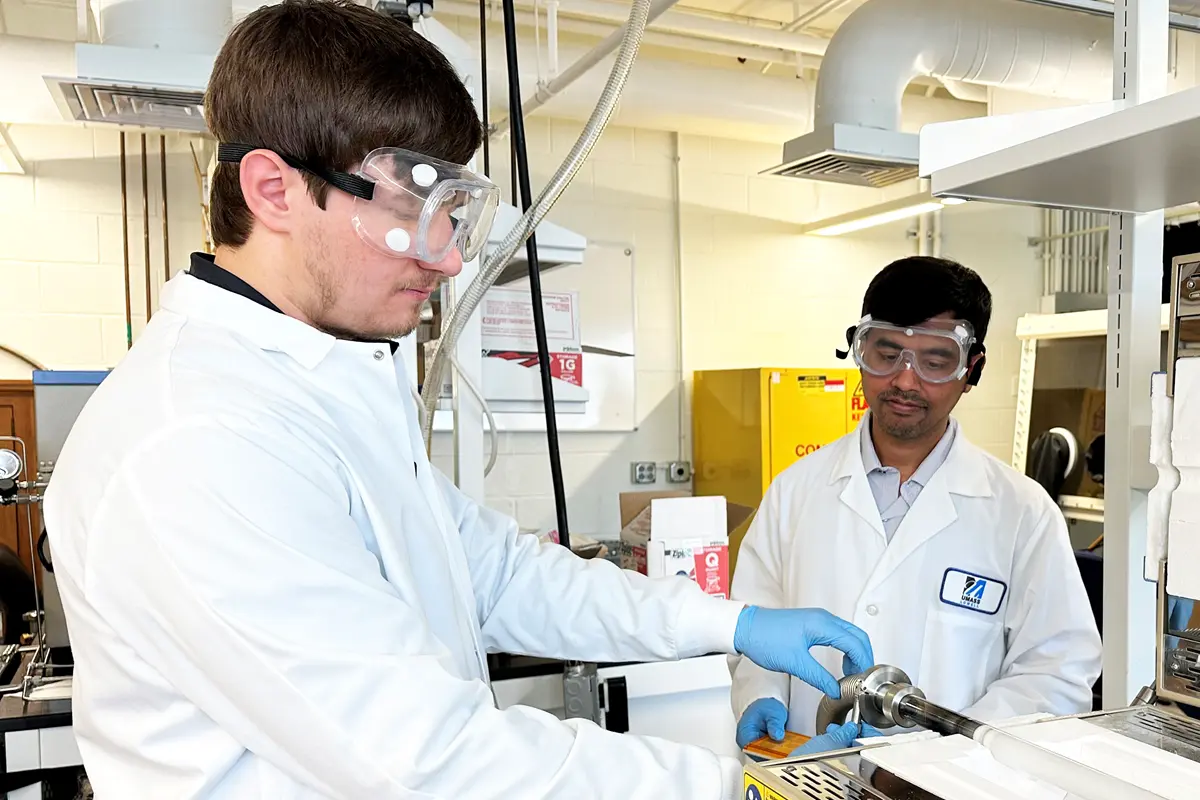 Asst. Prof. Anhar Bhuiyan watches Ph.D. student Ahmed Ibreljic work in the lab