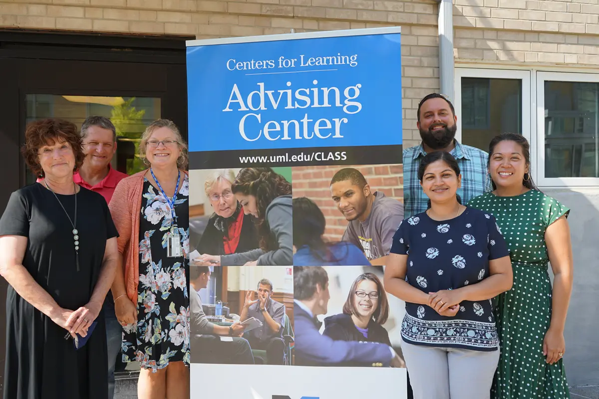 Advisors surround the Advising Center sign
